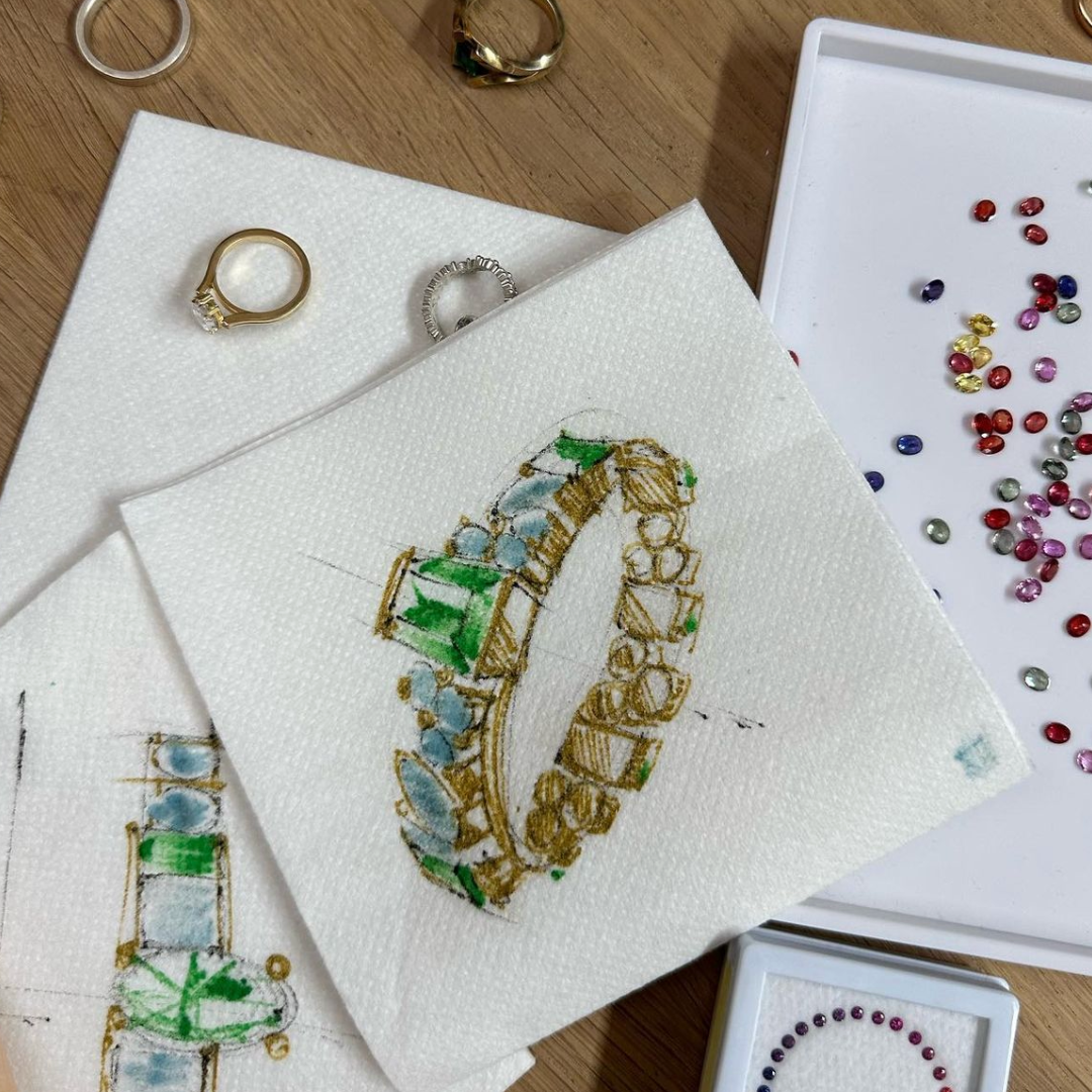 Hand-drawn jewelry sketches with loose stones at the bench